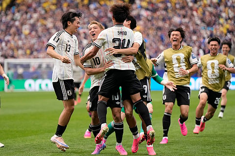 Japan players celebrate after their opening goal during the World Cup round of 32 soccer match between Brazil and Japan in Houston