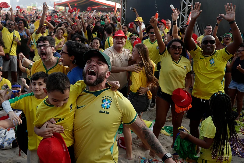 Brazil fans celebrate while watching the World Cup soccer match between Brazil and Japan on Copacabana Beach in Rio de Janeiro