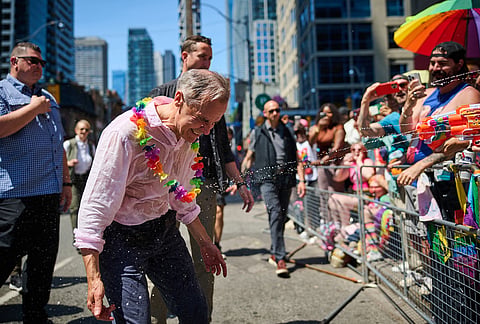 Canadian Prime Minister Mark Carney is sprayed with water as he takes part in the Toronto Pride Parade on Sunday, June 28, 2026. 