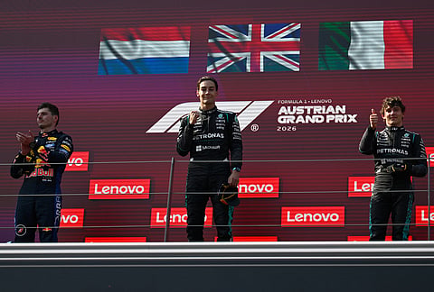 Race winner Mercedes driver George Russell of Britain, center, stands on the podium with second placed Red Bull driver Max Verstappen of the Netherlands, left, and third placed Mercedes driver Andrea Kimi Antonelli of Italy, after the Austrian F1 Grand Prix, in Spielberg, Austria, Sunday, June 28, 2026. 