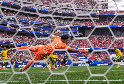 Canada's Stephen Eustaquio (7) scores their opening goal past South Africa goalkeeper Ronwen Williams (1) during the World Cup round of 32 soccer match between South Africa and Canada in Inglewood, California near Los Angeles.