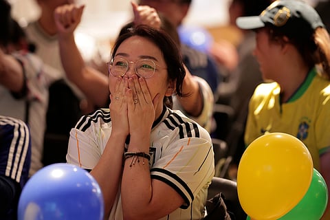 A Japan fan reacts after Brazil scored the equalizer during a World Cup soccer match between Brazil and Japan in the Liberdade district of Sao Paulo