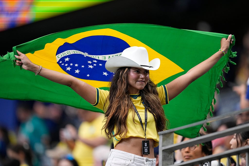 A fan holds a flag of Brazil before the World Cup round of 32 soccer match between Brazil and Japan in Houston - AP Photo/Ashley Landis