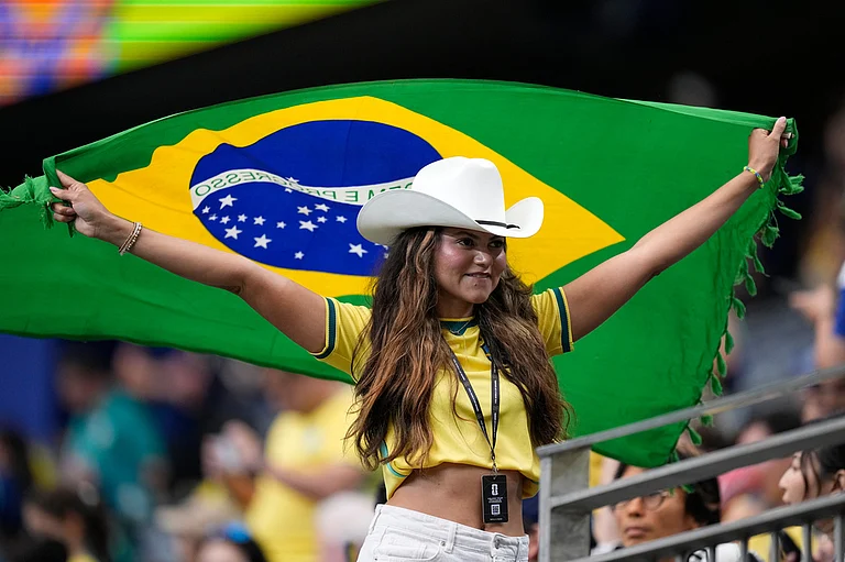 A fan holds a flag of Brazil before the World Cup round of 32 soccer match between Brazil and Japan in Houston - AP Photo/Ashley Landis