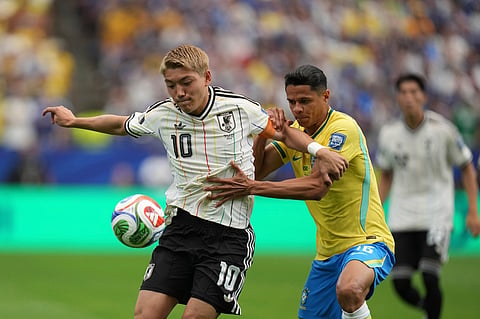 Japan's Ritsu Doan (10) challenges for the ball with with Brazil's Douglas Santos (16)during the World Cup round of 32 soccer match between Brazil and Japan in Houston