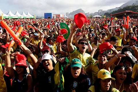 Brazil fans celebrate while watching the World Cup soccer match between Brazil and Japan on Copacabana Beach in Rio de Janeiro