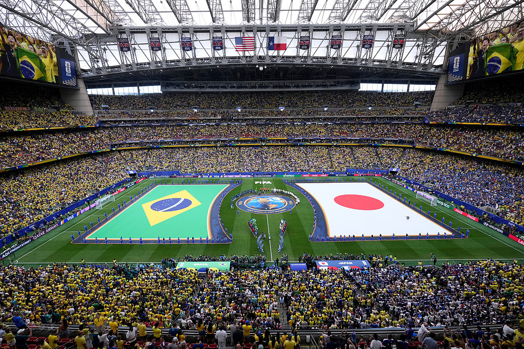 The teams from Brazil and Japan line up on the field for the national anthems during the teams' presentation before the World Cup round of 32 soccer match between Brazil and Japan in Houston. - Eric Smith/AP Photo