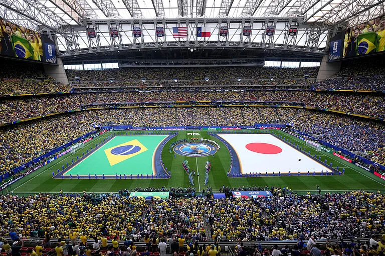 The teams from Brazil and Japan line up on the field for the national anthems during the teams' presentation before the World Cup round of 32 soccer match between Brazil and Japan in Houston. - Eric Smith/AP Photo