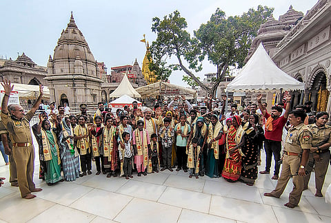 Police personnel stand guard as residents of Pandi village in Naugarh block of Chandauli district visit the 'Kashi Vishwanath Temple', in Varanasi, Uttar Pradesh. 