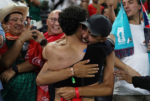 Morocco's Gessime Yassine, center left, celebrates with fans after winning the World Cup round of 32 soccer match between the Netherlands and Morocco in Guadalupe, near Monterrey, Mexico.