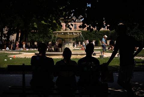 People enjoy the shade of the trees at Place des Vosges during a heat wave in Paris, Saturday, June 27, 2026. 