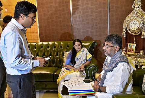 Karnataka Chief Minister DK Shivakumar interacts with a BLO official as he signs the enumeration form for the Special Intensive Revision (SIR) during the launch of the campaign in the state, at the CM's residence, in Bengaluru.