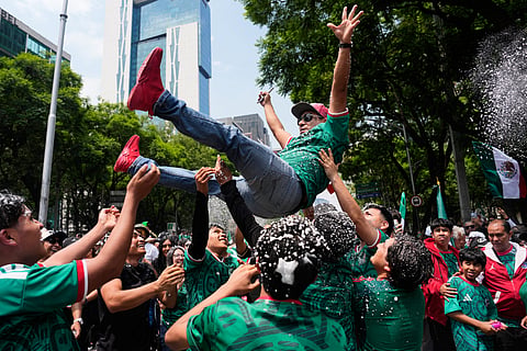 Soccer fans get revved up at a watch party on Reforma Ave., near the Angel of Independence monument, for the World Cup soccer match between Mexico and Ecuador, in Mexico City