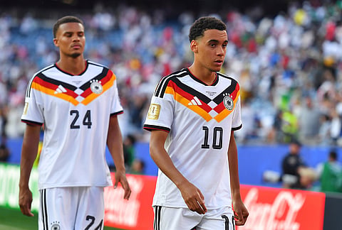 Germany's Jamal Musiala (10) and Malick Thiaw (24) walk off the field after losing to Paraguay in a shootout during the World Cup round of 32 soccer match in Foxborough, Mass., near Boston.