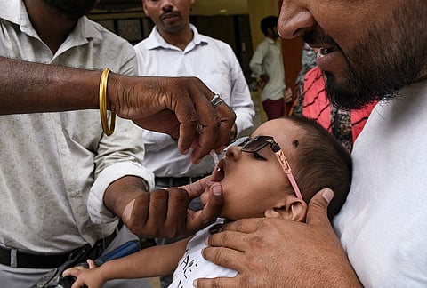 A health worker administers polio vaccine drops to a child during the National Pulse Polio Immunisation programme, at a hospital in Prayagraj.