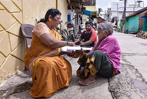 A Booth Level Officer (BLO) verifies voter details during the Special Intensive Revision (SIR) of electoral rolls, in Chikkamagaluru, Karnataka.