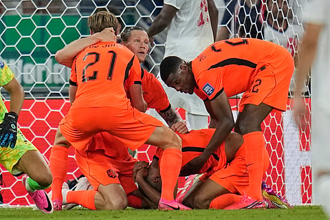 Netherlands' Cody Gakpo, kneeling, is congratulated by teammates after scoring his team's first goal during the World Cup round of 32 soccer match between the Netherlands and Morocco in Guadalupe, near Monterrey, Mexico, Monday, June 29, 2026.