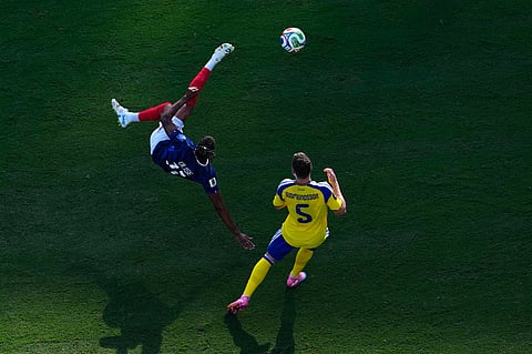 France's Michael Olise (11) shoots on Sweden's Gabriel Gudmundsson (5) during the World Cup round of 32 soccer match