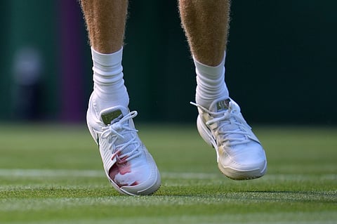 Italy's Jannik Sinner's shoes show a red stain during the men's singles match against Miomir Kecmanovic of Serbia at the Wimbledon Tennis Championships in London, Monday, June 29, 2026.