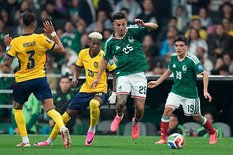 Mexico's Roberto Alvarado (25) battles for the ball with Ecuador's Nilson Angulo (20) during the World Cup round of 32 soccer match between Mexico and Ecuador in Mexico City, Tuesday, June 30, 2026.