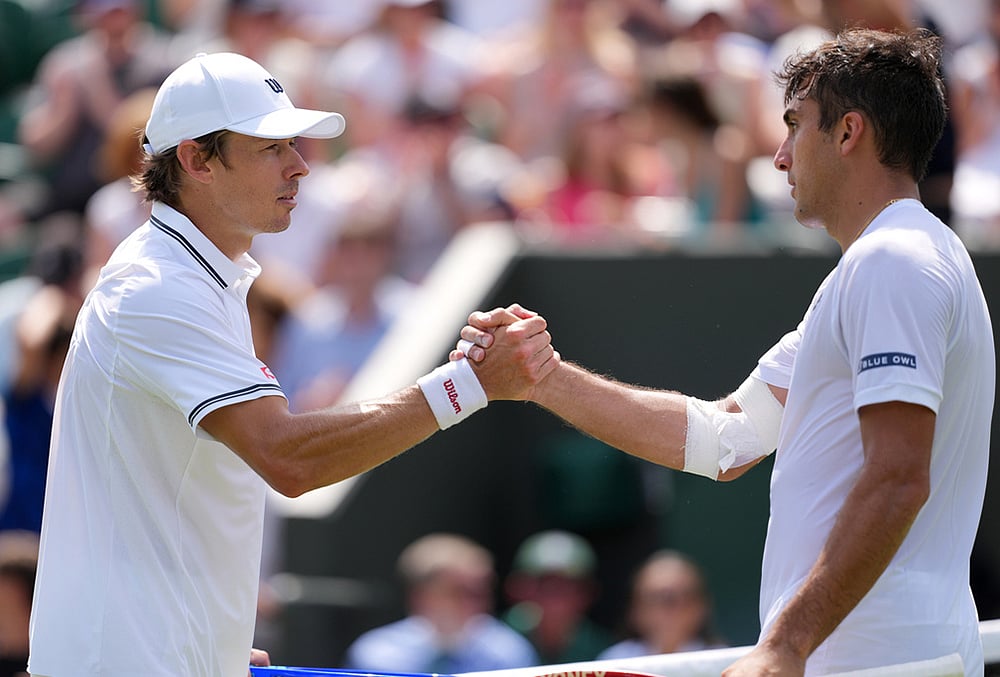 Roman Andres Burruchaga of Argentina and Alex de Minaur of Australia, left, shake hands after the men's singles match at the Wimbledon Tennis Championships in London, Tuesday, June 30, 2026. - | Photo: AP/Kin Cheung