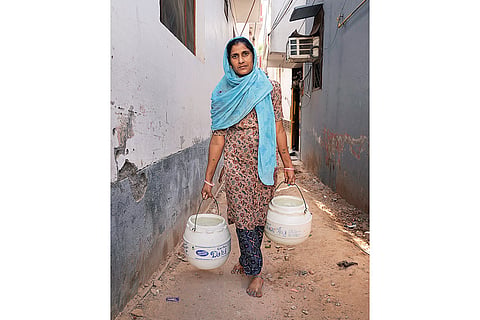 Daily Struggle: A woman returning home after filling water from a tanker at Rajokri’s Harijan Basti in Delhi