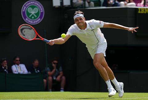 Taylor Fritz of the United States returns the ball to Dusan Lajovic of Serbia in their first round men's singles match at the Wimbledon Tennis Championships in London, Tuesday, June 30, 2026.