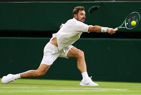 Stan Wawrinka of Switzerland returns the ball to Matteo Berrettini of Italy in their first round men's singles match at the Wimbledon Tennis Championships in London, Tuesday, June 30, 2026. 