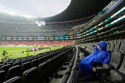 Fans wait as the World Cup round of 32 soccer match between Mexico and Ecuador is delayed due to a thunderstorm