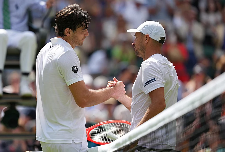 Taylor Fritz of the United States, left, and Dusan Lajovic of Serbia shake hands at the net at the end of their first round men's singles match at the Wimbledon Tennis Championships in London, Tuesday, June 30, 2026. - | Photo: AP/Kirsty Wigglesworth