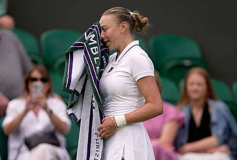 Amanda Anisimova of the United States uses a towel to wipe her face during the women's singles match against Lina Gjorcheska of North Macedonia at the Wimbledon Tennis Championships in London, Tuesday, June 30, 2026.