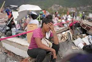 | Photo: AP/Matias Delacroix : Khaterine Roa cries as members of the Los Angeles County Fire Department search for survivors at a building that collapsed during the earthquakes that struck La Guaira, Venezuela.