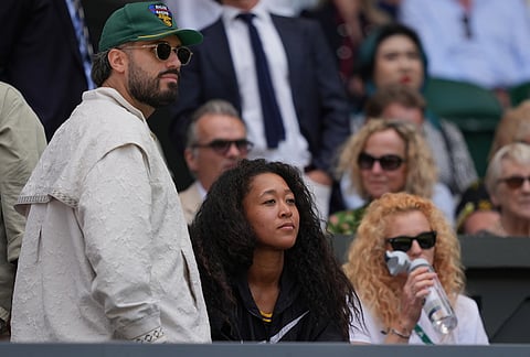 Japanese player Naomi Osaka, centre, watches the first round women's singles match between Iga Swiatek of Poland and Taylor Townsend of the United States at the Wimbledon Tennis Championships in London, Tuesday, June 30, 2026.