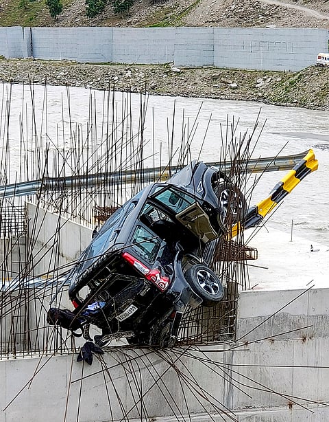 A sports utility vehicle (SUV) remains lodged on the iron reinforcement bars of an under-construction bridge after reportedly crashing through roadside barriers near the north portal of the Atal Tunnel, in Lahaul and Spiti district, Himachal Pradesh.