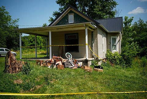 Police tape surrounds a home where authorities say they removed 16 children and arrested four adults in Hamden, Ohio.