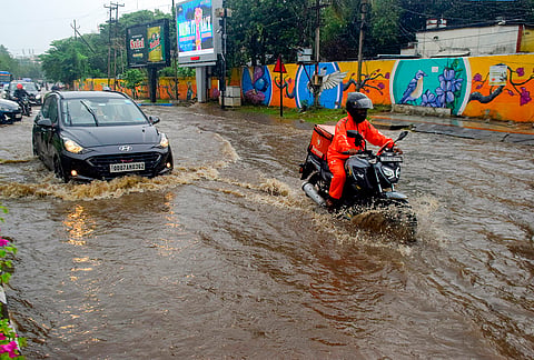 Vehicles ply on a waterlogged road after heavy rain, in Bhubaneswar.