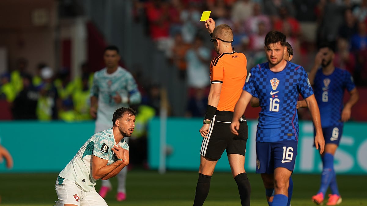 Referee Espen Eskås, of Norway, shows a yellow card to Portugal's Ruben Dias during the World Cup round of 32 soccer match against Croatia in Toronto, Thursday, July 2, 2026. - (AP Photo/Stephanie Scarbrough)