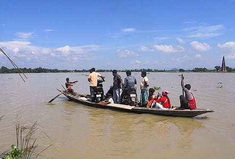 People cross a flood-affected area on a boat, at Hiloikhunda village in Morigaon district. 