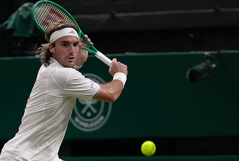 Stefanos Tsitsipas of Greece returns the ball to Novak Djokovic of Serbia in their second round men's singles match at the Wimbledon Tennis Championships in London, Wednesday, July 1, 2026. 