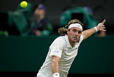 Stefanos Tsitsipas of Greece returns the ball to Novak Djokovic of Serbia in their second round men's singles match at the Wimbledon Tennis Championships in London, Wednesday, July 1, 2026. 