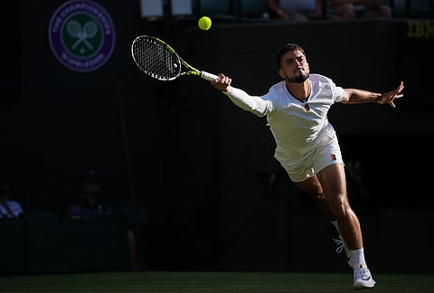Dino Prizmic of Croatia returns the ball to Felix Auger-Aliassime of Canada in their second round men's singles match at the Wimbledon Tennis Championships in London, Wednesday, July 1, 2026.  