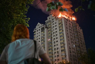 | Photo: AP/Danylo Antoniuk : A woman looks at an apartment building burning after a Russian missile attack in Kyiv, Ukraine.