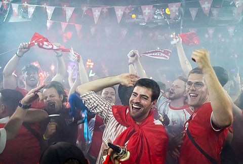 Swiss supporters react at a public viewing of the World Cup round of 32 soccer match between Switzerland and Algeria, in the fan zone "Village su Soir" in Geneva, Switzerland, Friday, July 3, 2026.