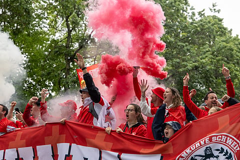 Switzerland fans march through the rain towards BC Place for a World Cup round of 32 match against Algeria, in Vancouver, British Columbia, Thursday, July 2, 2026
