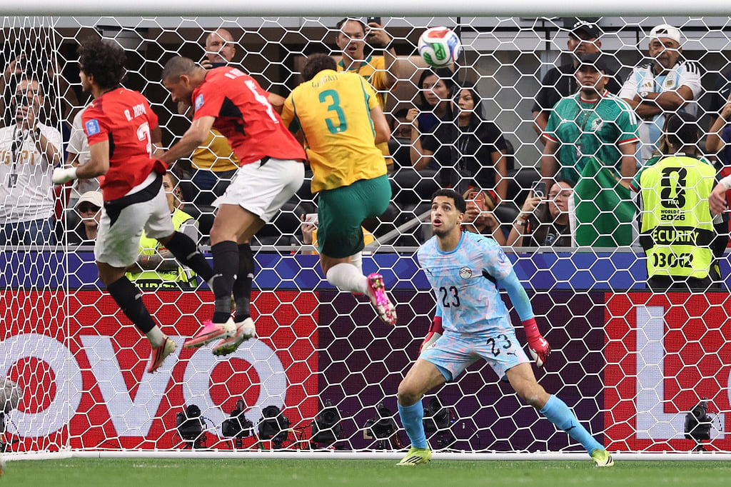 Egypt goalkeeper Mostafa Shoubir (23) looks at the ball as Egypts Mohamed Hany, left, scores an own goal during the World Cup round of 32 soccer match between Australia and Egypt in Arlington