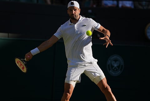 Grigor Dimitrov of Bulgaria returns the ball to Jakub Mensik of Czech Republic in their second round men's singles match at the Wimbledon Tennis Championships in London, Thursday, July 2, 2026. 