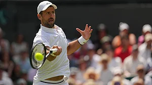 (AP Photo/Kin Cheung) : Novak Djokovic of Serbia returns the ball to Arthur Rinderknech of France in their third round mens singles match at the Wimbledon Tennis Championships in London, Friday, July 3, 2026.