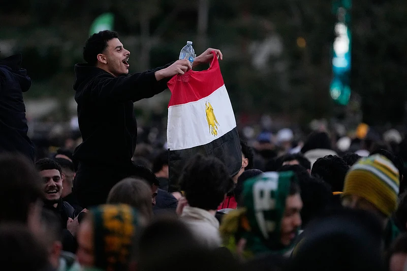 A fan of Egypt waves a flag after watching large screens in a park in Sydney, Saturday, July 4, 2026, as Australia and Egypt play in their World Cup round of 32 soccer match