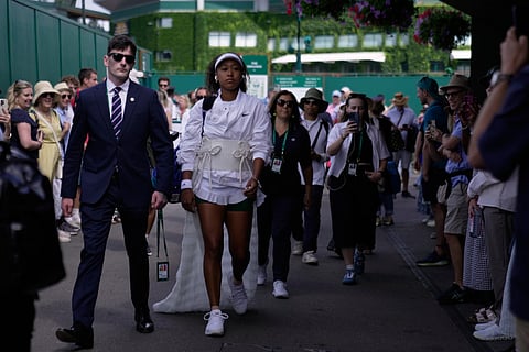 Naomi Osaka of Japan walks towards court 2 to play her second round women's singles match against Anastasia Gasanova of Russia, at the Wimbledon Tennis Championships in London, Wednesday, July 1, 2026.