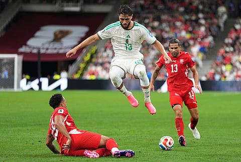 Switzerland's Noah Okafor (19) falls as Algeria's Jaouen Hadjam (13) jumps over him to take control of the ball during the World Cup round of 32 soccer match between Switzerland and Algeria in Vancouver, British Columbia, Thursday, July 2, 2026. 